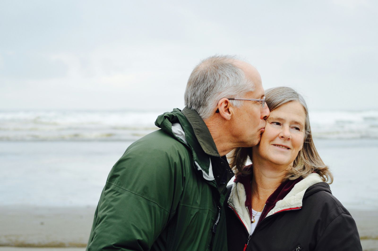 An older couple walking together on a beach